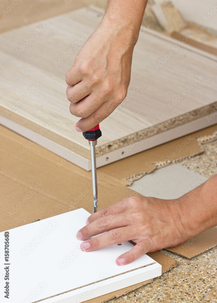 Asian Man's Hand Using Screw Driver Assembling Wooden Furniture Asian Man's Hand Using Screw Driver Assembling Wooden Furniture