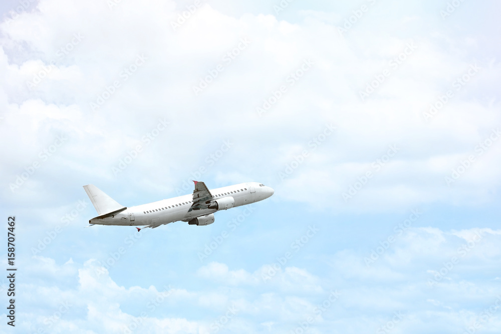 Fototapeta premium Airplane is flying in a blue sky.