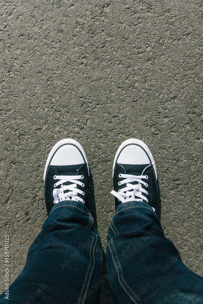 Asphalt with two shoes, personal perspective from above