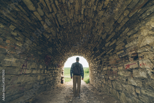 man stands in old castle tunnel photo