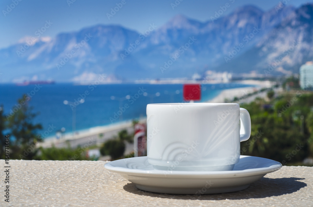 Morning cup of coffee or tea with sea and mountain background