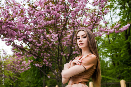 Spring beauty girl near Blooming sakura tree. Romantic young woman portrait
