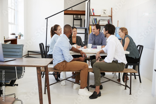 Creative team meeting around a table in an office