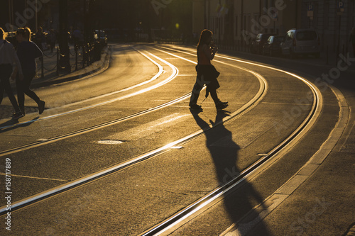 passer-by silhouette on walkway in the sunset light, urban landscape in the evening