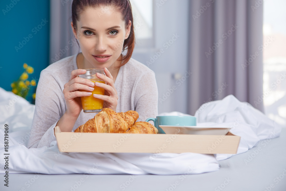 Young beautiful woman having breakfast in bed. Young beautiful woman having breakfast in bed.