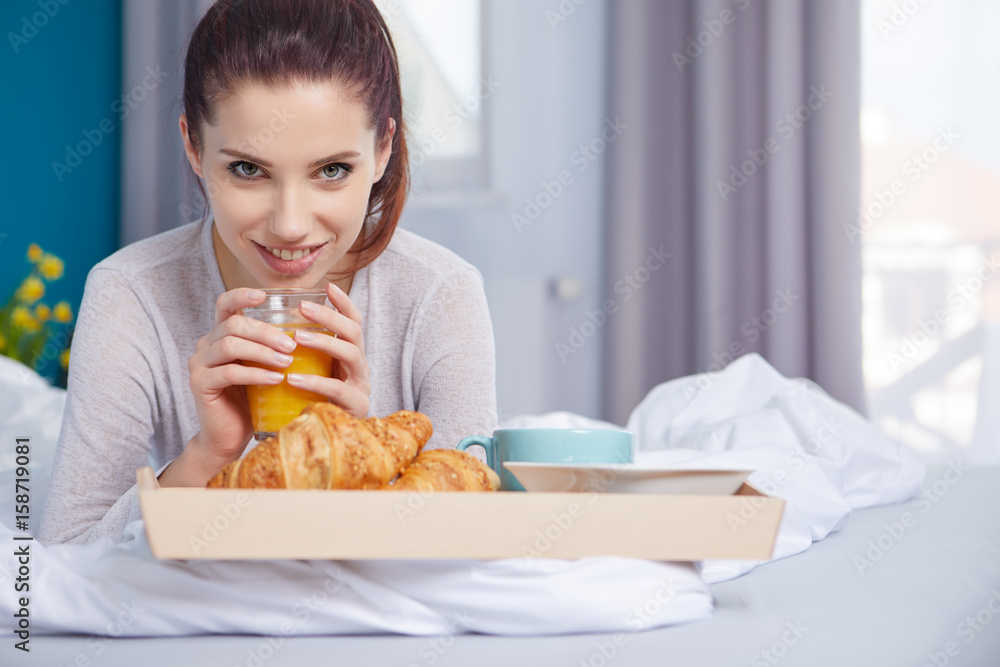 Young beautiful woman having breakfast in bed.