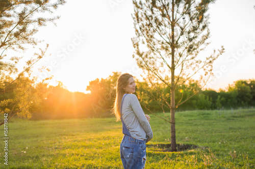 Pregnant woman hugging her belly outdoors © satura_