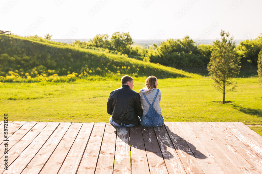 Love couple hugging on a pier in nature back view
