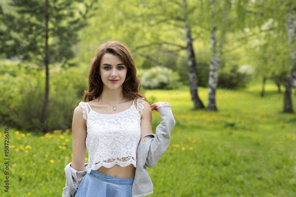 Portrait of a girl with long hair against the background of grass and trees Portrait of a girl with long hair against the background of grass and trees