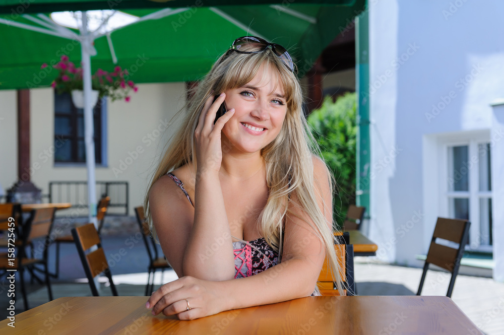 Beautiful caucasian woman talking on the phone at a cafe Beautiful caucasian woman talking on the phone at a cafe