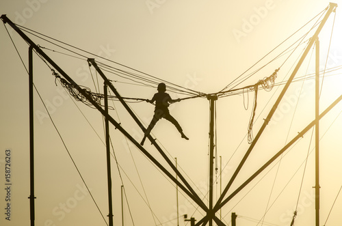 Fotografie, Obraz Trampoline rope sunset child silhouette