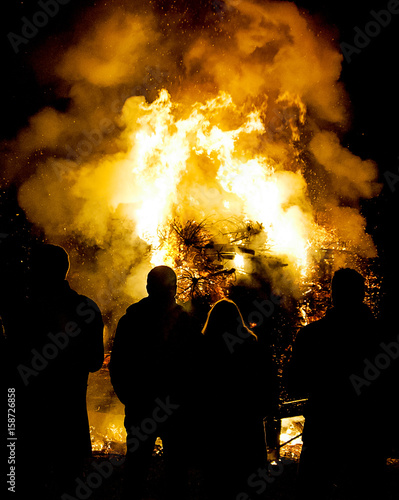 Lagerfeuer mit feiernden Leuten in der Nacht