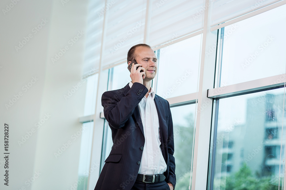 A businessman talking on a mobile phone,Businessman talking on the phone in office,Senior businessman,Portrait of businessman talking on mobile phone,business concept A businessman talking on a mobile phone,Businessman talking on the phone in office,Senior businessman,Portrait of businessman talking on mobile phone,business concept