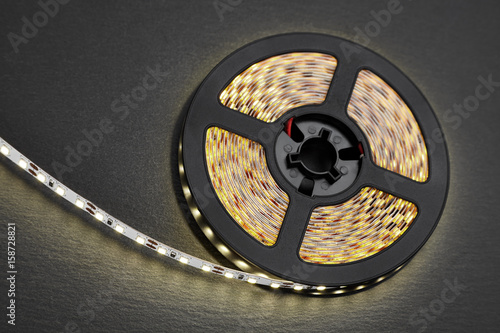 Reel of a diode strip with warm light on a stone dark background