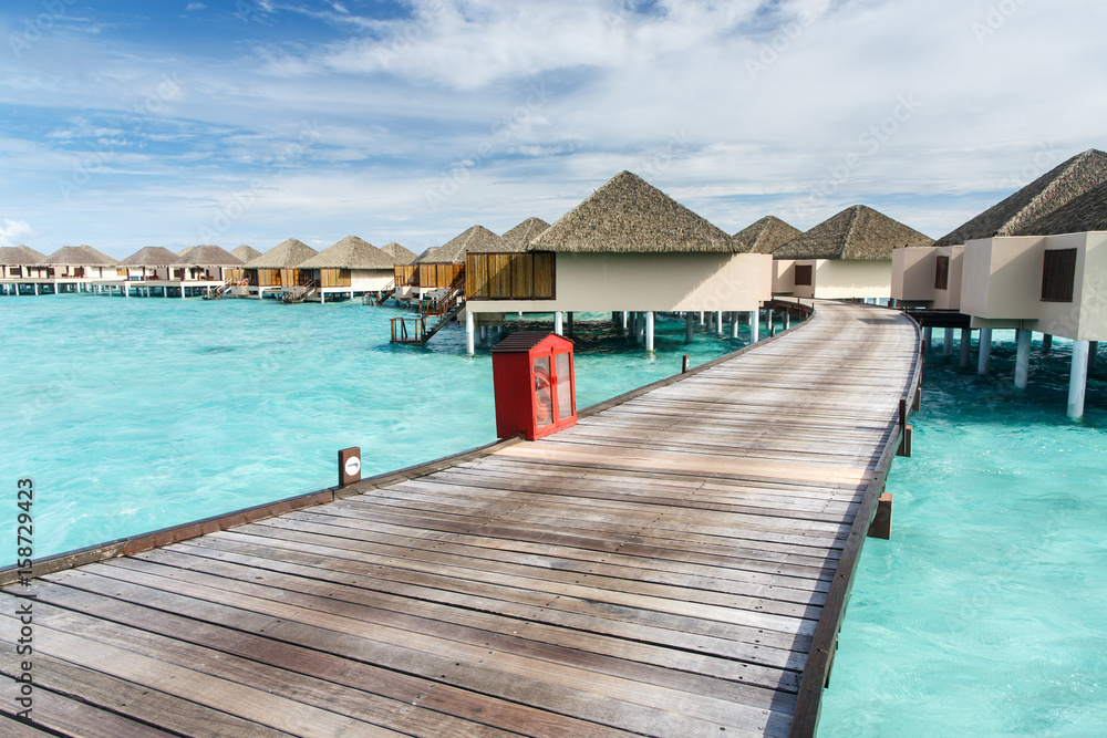 Fototapeta premium Walk way to water villa on crystal clear water at island