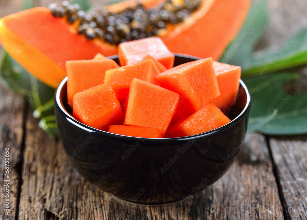 papaya slice in bowl on wood papaya slice in bowl on wood