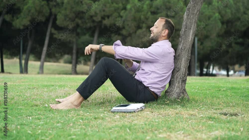 Young businessman relaxing on grass in park
Young businessman relaxing on grass in park