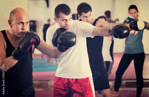 Portrait of females and males training in boxing gloves