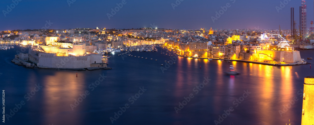 Panoramic aerial skyline view of ancient defences of Three cities, three fortified cities of Birgu, Senglea and Cospicua and Grand Harbor, as seen from Valletta at night, Malta.