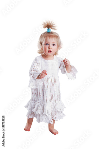 Cute small baby girl in hand made lace dress sitting and playing with ball on white background