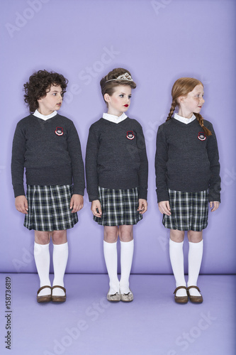 Three girls wearing school uniform standing side by side
