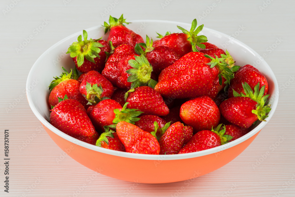 Red fresh strawberries in a bowl isolated on white background. Close up view. Red fresh strawberries in a bowl isolated on white background. Close up view.