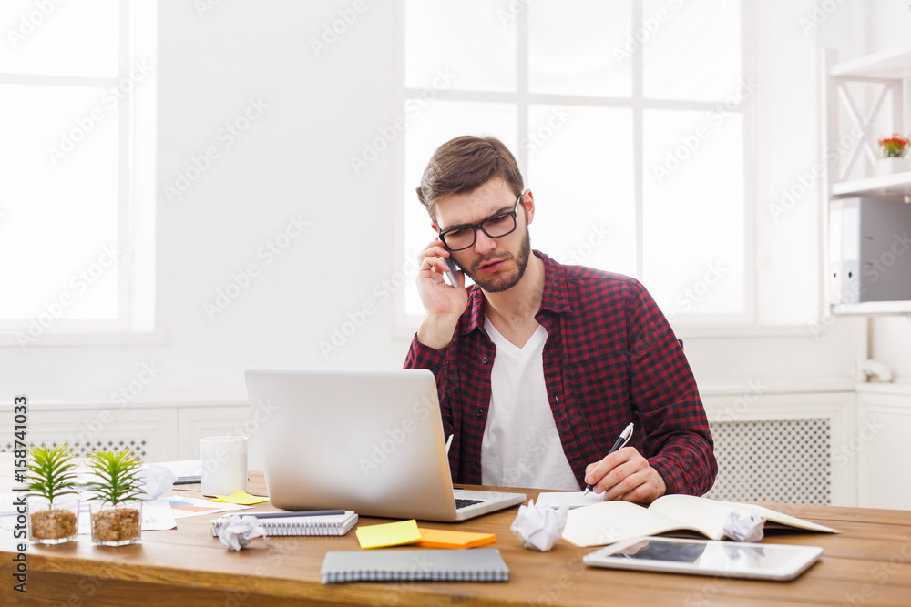 Young concentrated businessman read documents in modern white office Young concentrated businessman read documents in modern white office