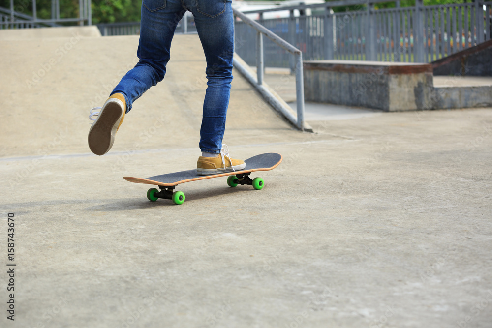 young skateboarder legs riding skateboard at skatepark young skateboarder legs riding skateboard at skatepark