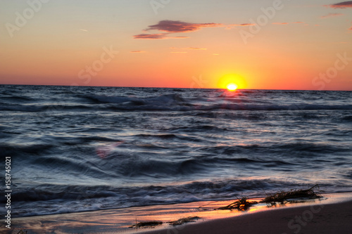 Sunset Beach Background. Sunset sky and waves crashing on the beach along the Lake Michigan coast. 