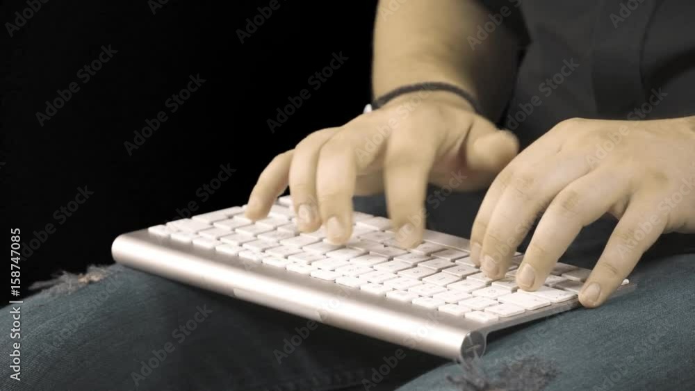 Man hands typing on a computer keyboard. Black background Man hands typing on a computer keyboard. Black background