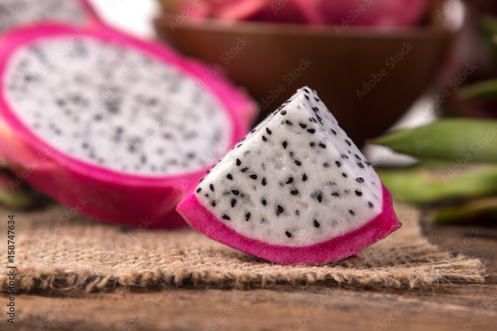 Close up sliced Fresh Dragon fruit or Pitahaya fruit on the wooden background Close up sliced Fresh Dragon fruit or Pitahaya fruit on the wooden background