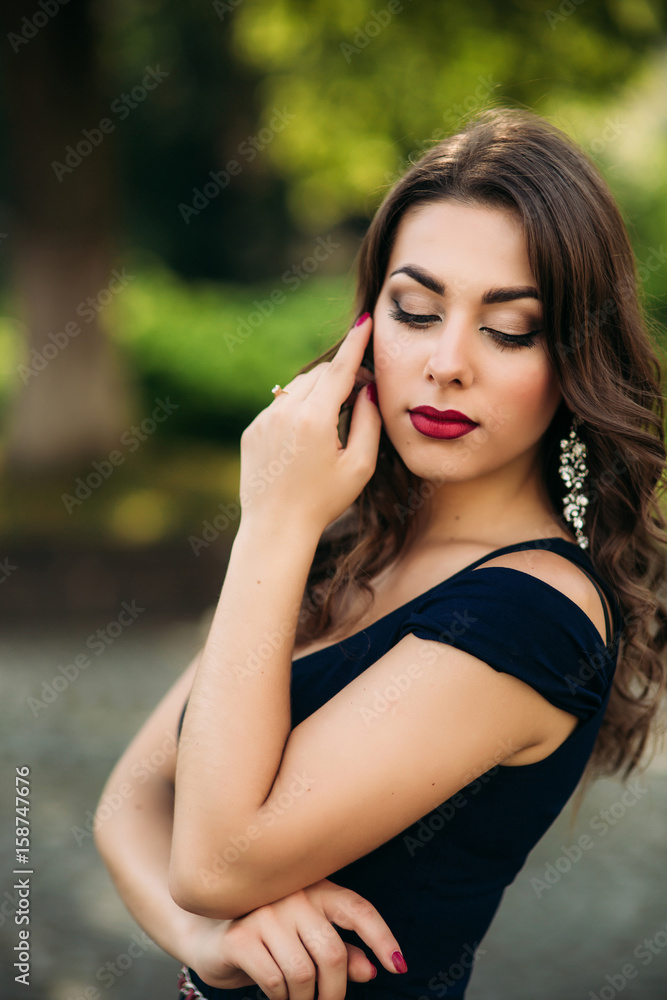 A beautiful girl in a blue dress is walking in the park. Sunny day. Summer.
A beautiful girl in a blue dress is walking in the park. Sunny day. Summer.