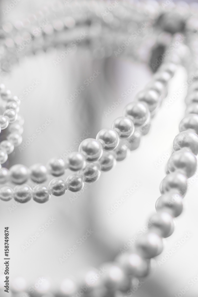 Necklace of white pearls on a mirror surface Necklace of white pearls on a mirror surface