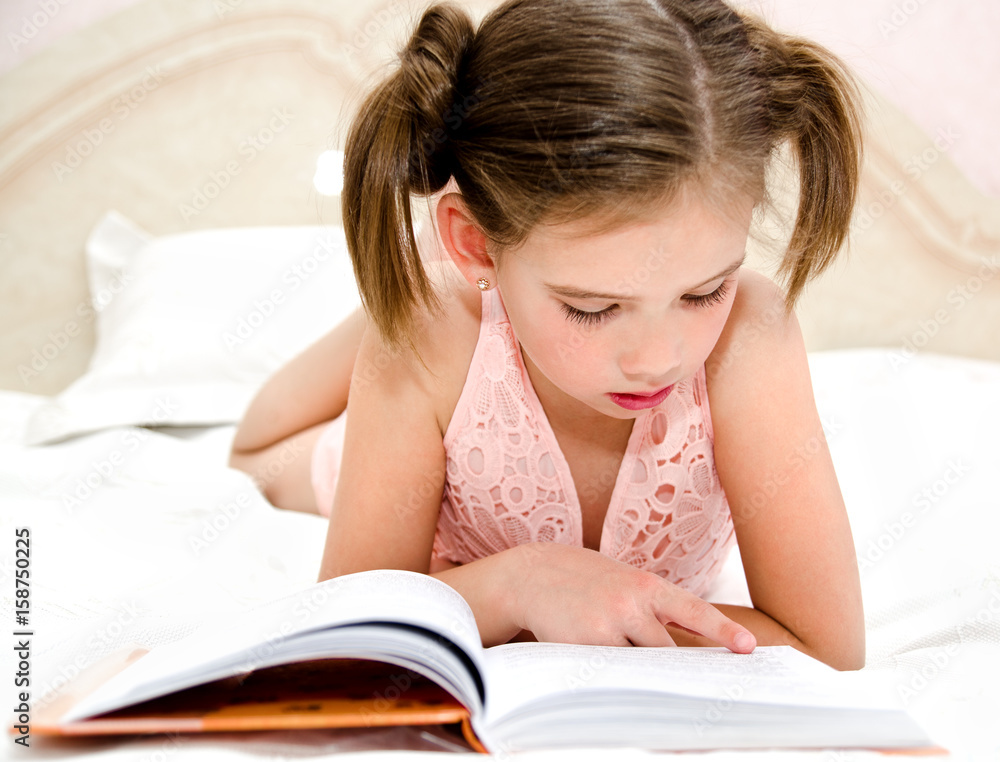 Adorable little girl child is reading a book Adorable little girl child is reading a book