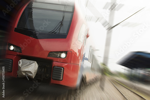 Modern high-speed train on a clear day with motion blur. Beautiful railway station with modern red commuter train.