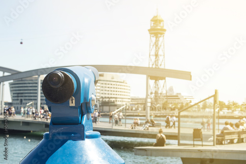 Public telescope and Maremagnum Shopping Centre, Port and cable car tower in background in Barcelona, Spain