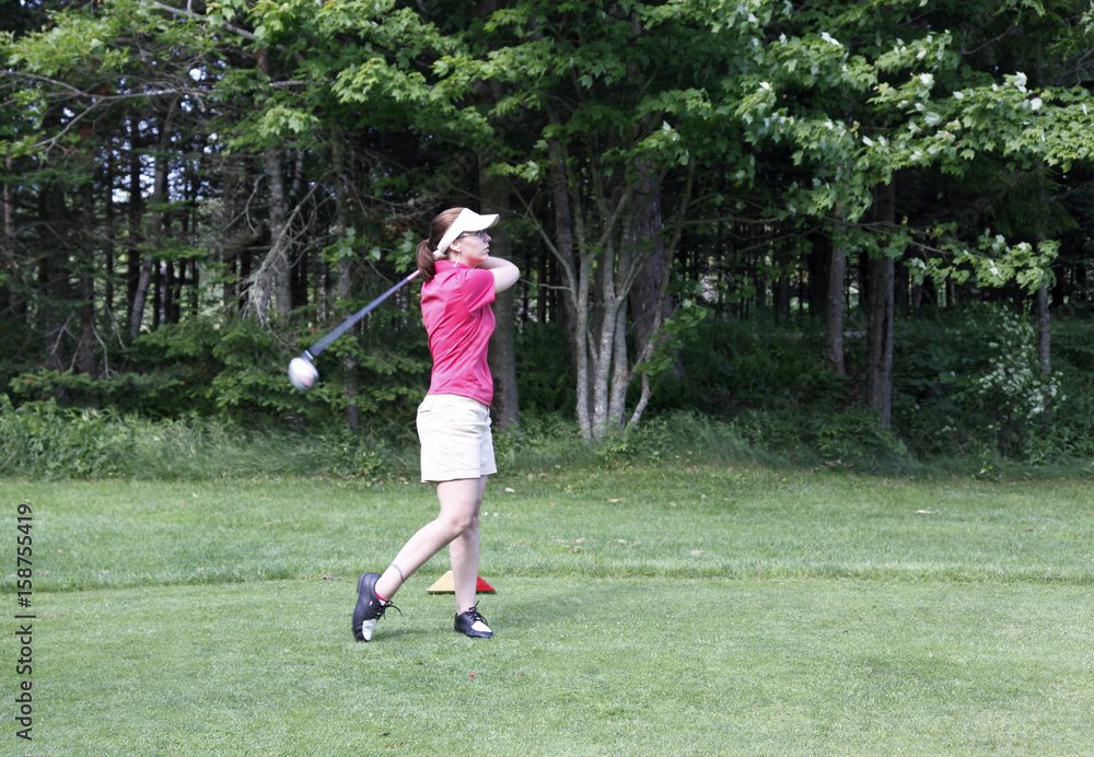 Obraz premium young woman takes a golf swing 