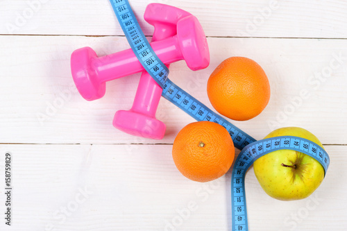 ideal size concept, dumbbells weight with measuring tape, fruit