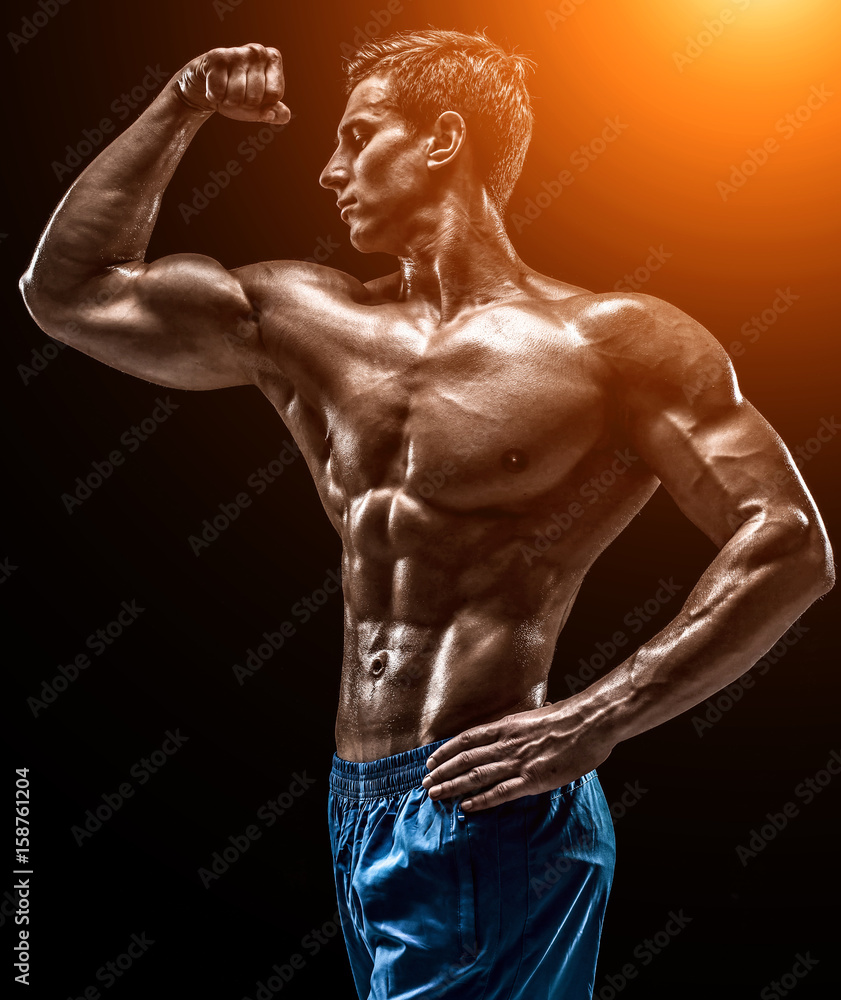 Muscular and fit young bodybuilder fitness male model posing ove Muscular and fit young bodybuilder fitness male model posing ove