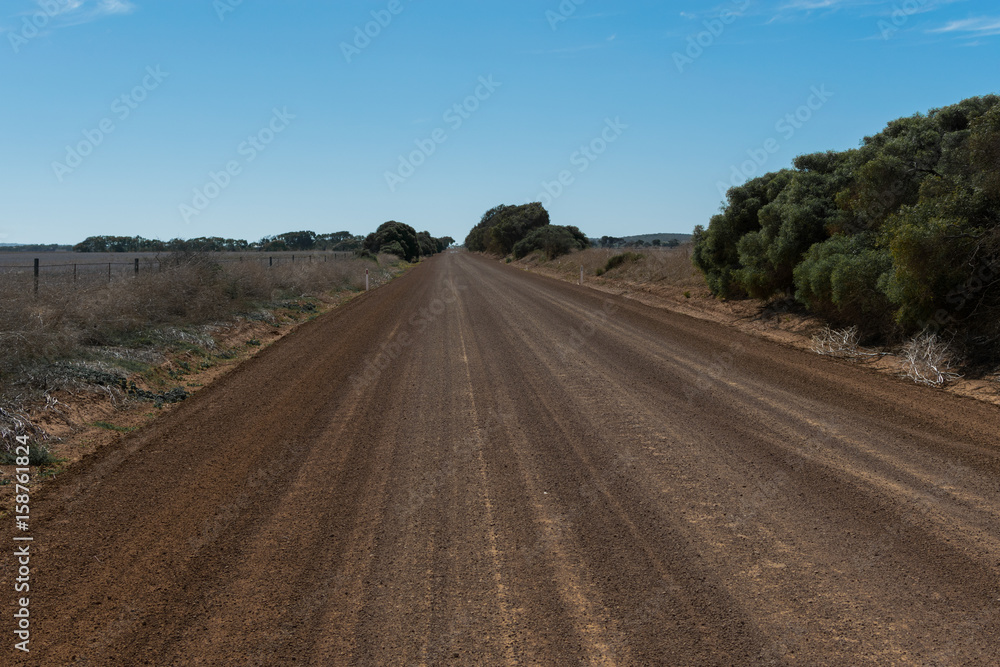 Gravel road passing through farming country