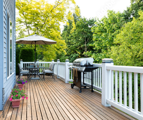 Home deck and patio with outdoor furniture and BBQ cooker with bottled beer photo