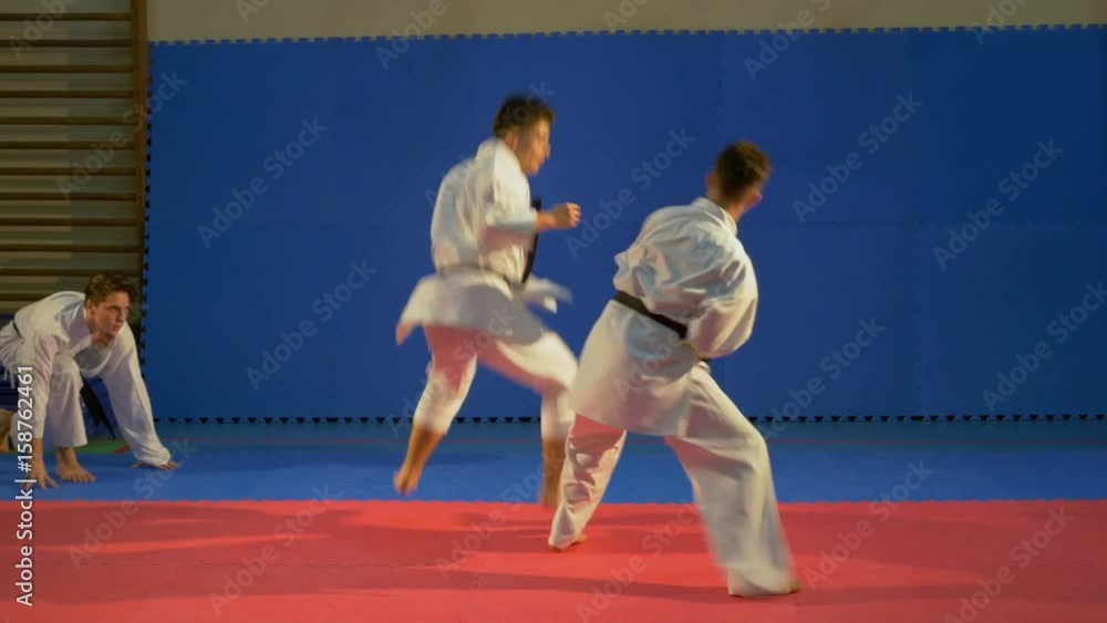 Karate fighters practicing attack and blocking techniques at the dojo Karate fighters practicing attack and blocking techniques at the dojo
