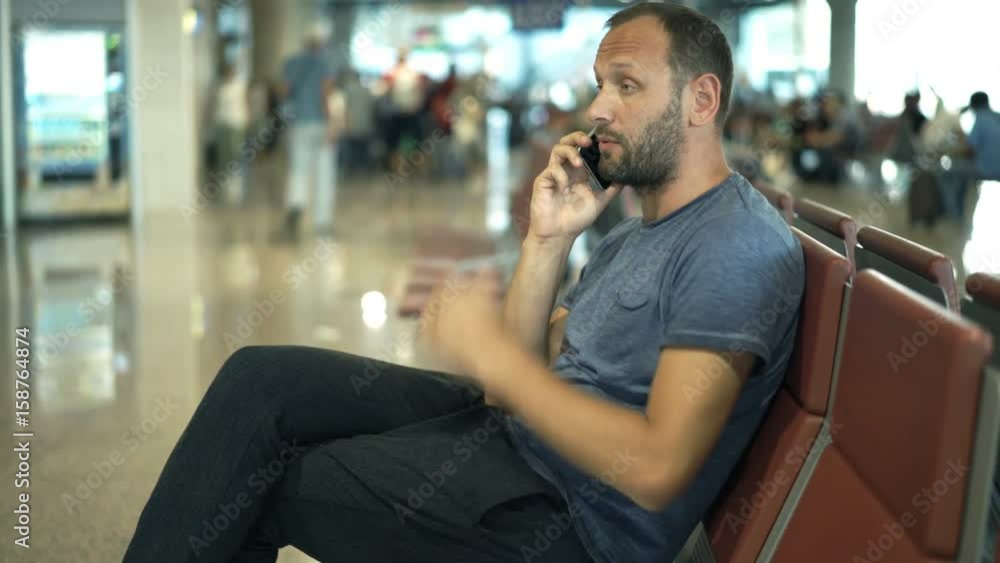 Angry man talking on cellphone and waiting for late plane at airport
Angry man talking on cellphone and waiting for late plane at airport