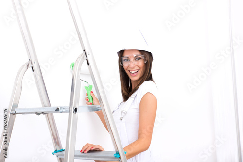 Beautiful young woman painting a Apartment