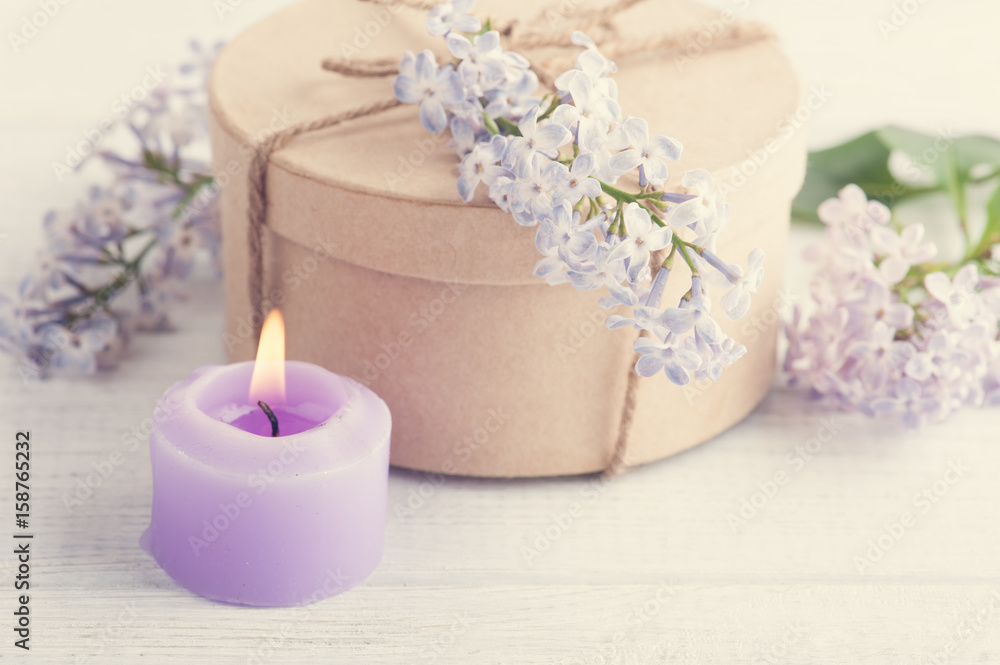Lit purple candle and lilac flowers