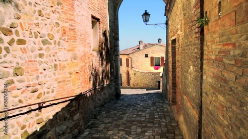 medieval alley with waving shadows on brick walls in Italian village