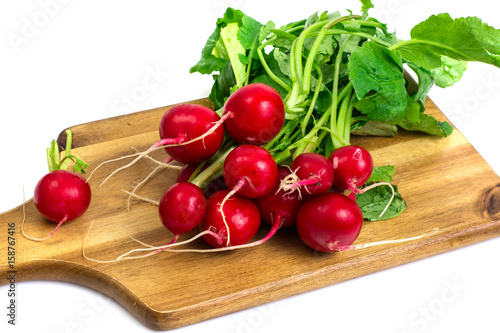 Washed red young radish on wooden board