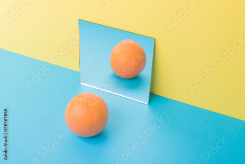 Grapefruit on blue table isolated over yellow background