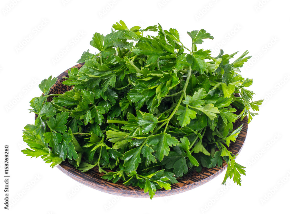 Obraz premium Fresh green parsley on wooden plate