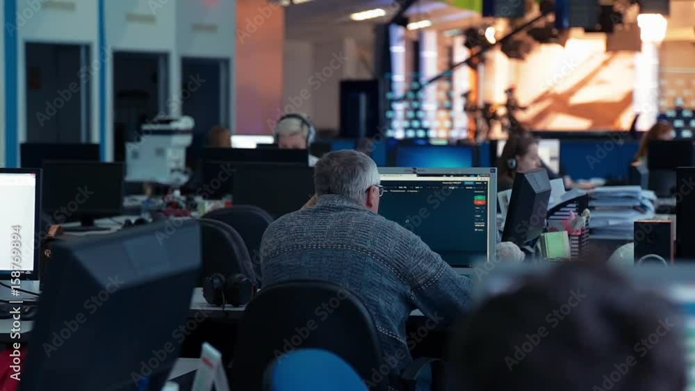 A man is working at a computer in the office A man is working at a computer in the office